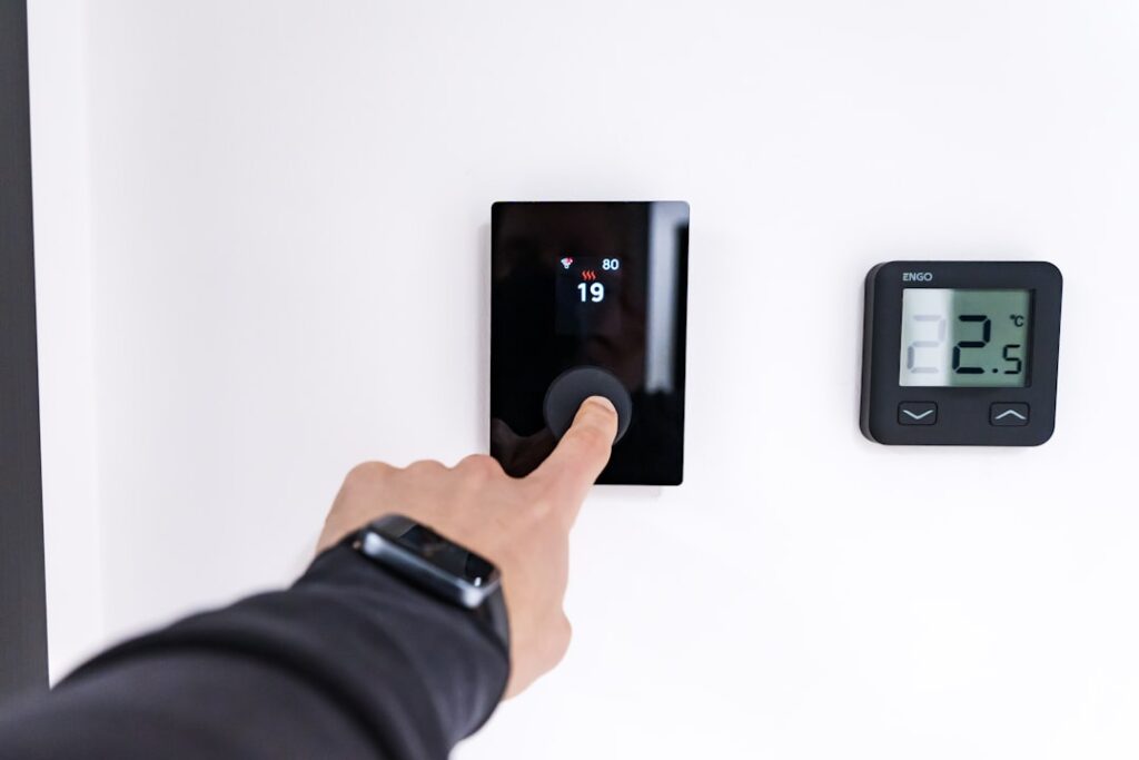 Smart Ways to Cool Your Home Efficiently: An Ohio Guide 8 Homeowner adjusting a smart thermostat for summer efficiency - summer energy saving tips for ohio homeowners